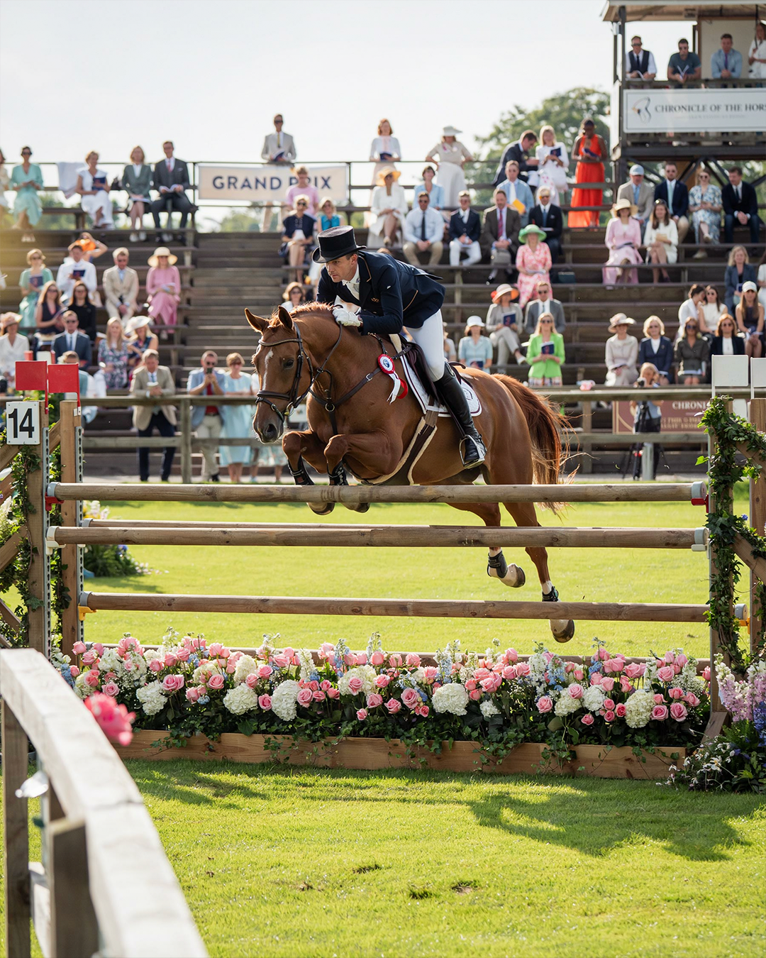 An accomplished American show jumper and elegant warmblood horse clearing a classic grand prix fence during a prestigious equestrian competition in the late 1980s, beautifully manicured grass arena, tasteful floral jumps, spectators dressed in refined attire, bright natural afternoon light.